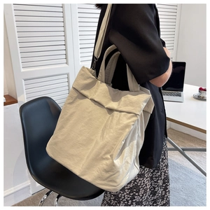 Detailed side view of a beige lightweight nylon tote bag for commuting and casual use