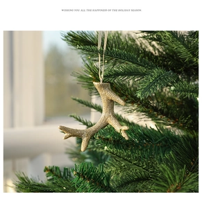 Golden textured reindeer antler hanging ornament on green Christmas tree branch