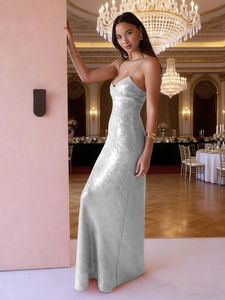 Détail d'une robe de soirée à paillettes argentées avec fines bretelles en salle de luxe