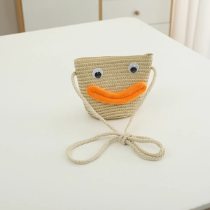 Détail d'un sac en paille pour enfants avec des yeux mignons et une bouche orange vive