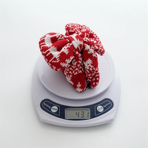 Detailed weight measurement of a red and white knitted Christmas bow hair tie, 43.1g