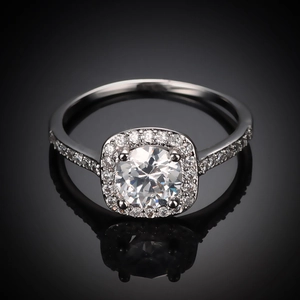 Macro shot of silver ring featuring a round main stone and square diamond-pave halo