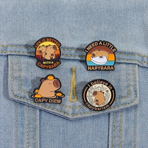 Set of four cute enamel capybara pins displayed on a blue denim jacket pocket