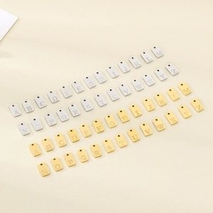 Detailed top view of 26 rectangle A-Z alphabet charms in gold and silver stainless steel