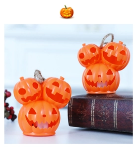 Close-up of two stacked pumpkin Halloween lights with rope hangers on a festive desk