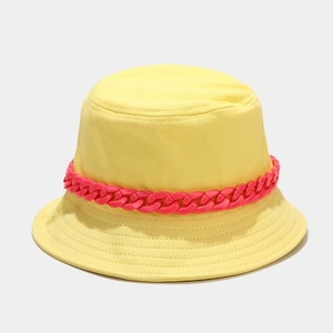 Dettaglio cappello alla pescatora giallo in cotone con vistosa catena rosa in plastica