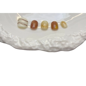 Handmade brown latte swirl press-on nails set with glossy finish on a white tray