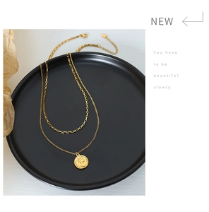 Detail of double-layer gold coin necklace with portrait relief on black tray