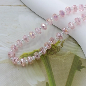 Detailed close-up of 6mm faceted pink crystal glass beads with vibrant light refraction