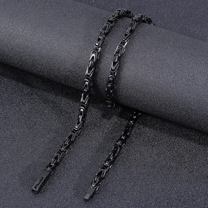 Detail of 6mm black Byzantine chain link and rectangular clasp on dark background