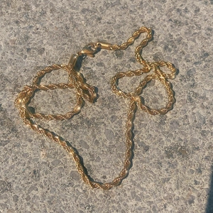 Golden titanium steel rope chain necklace with durable lobster clasp in outdoor setting