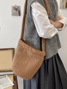Brown fuzzy plush bucket bag with shoulder strap for casual winter outfit styling