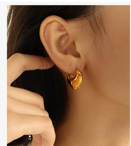 Close-up of elegant irregular circular gold earrings worn by a model for a modern look