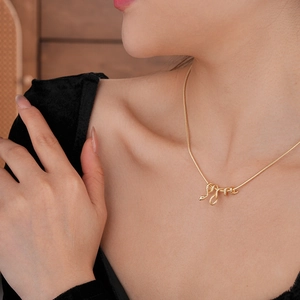 Dettaglio della collana con ciondolo a serpente placcata in oro su una modella femminile