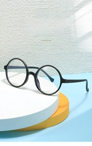 Close-up of stylish black round frames for children with transparent lenses on a display stand