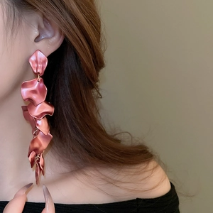 Detailed view of matte pink layered petal long tassel earrings worn by a model