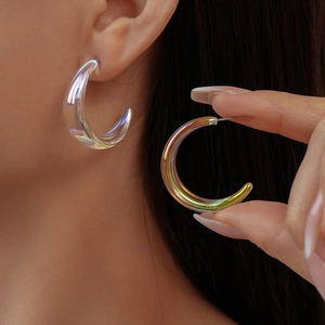 Detailed view of iridescent aurora C-shaped acrylic earrings with light refraction