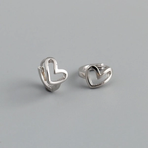 Detailed close-up of heart-shaped silver earrings with elegant metallic finish on grey background