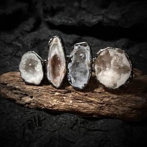 Macro shot of natural geode agate slices with silver plated metal edges on wood