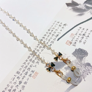 Golden multi-use glasses chain with transparent crystal beads and black bow accents