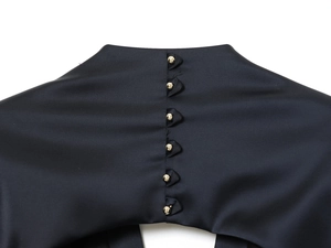 Gros plan sur les boutons en métal doré sur un tissu en satin noir haut de gamme