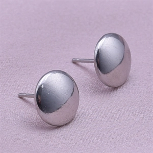 Macro shot of minimalist 304 stainless steel flat circle stud earrings on purple fabric