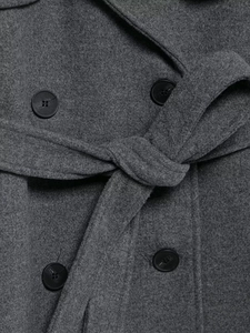 Detail of dark gray wool coat showing waist belt buckle and double-breasted buttons