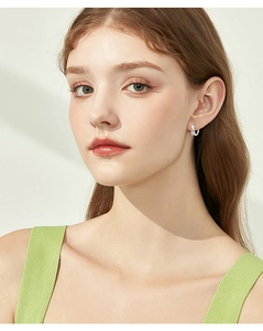 Detailed view of silver twist hoop earrings with pavé set moissanite on female model