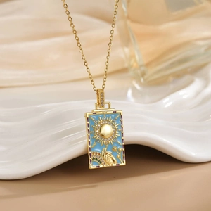 Macro detail of gold tarot sun pendant featuring Le Soleil engraving and blue zircon inlay