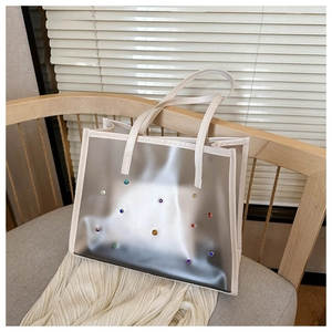 Close-up of clear tote bag with colorful rhinestones and cream white trim details