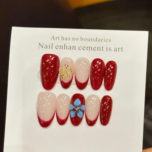 Faux ongles faits main rouges style français avec fleurs 3D et finition brillante