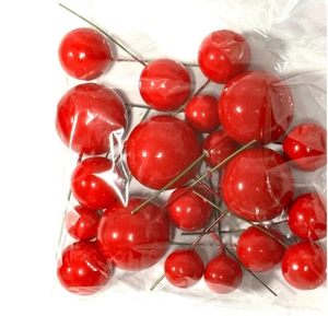 Detail of red foam berries on wire stems in transparent bag for cake decoration