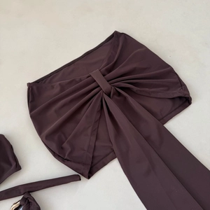 Detailed flat lay of dark chocolate brown three-piece bikini with a large central knot tie