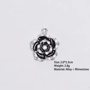 Detail view of a camellia flower pendant with black oil drip and sparkling rhinestones