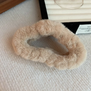 Close-up of khaki plush faux fur hair claw clip with soft fluffy texture on neutral base