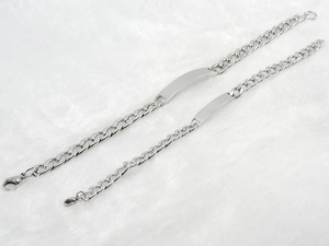 Polished stainless steel NK curb bracelets with curved ID plates on white plush surface