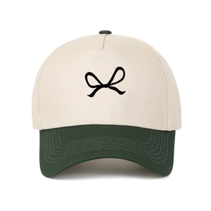 Detail of contrast stitch five-panel cap with bow embroidery and cream canvas crown