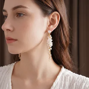 Elegant long flower pearl tassel earrings worn by a model in a high-fashion side view