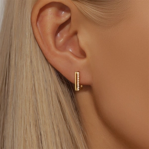 Detailed macro shot of a gold S925 silver earring with sparkling cubic zirconia stones