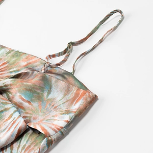 Detailed close-up of the satin strap and abstract colorful floral print on the summer top