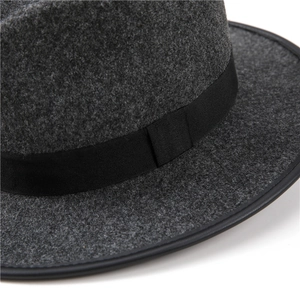 Detailed macro view of dark grey wool felt hat with black ribbon and leather trim