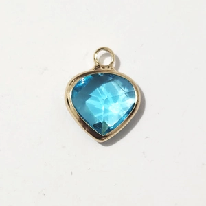 Makroansicht Herzanhänger mit blauem Edelstein und Goldrand für DIY-Schmuckherstellung