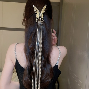 Vue de dos détaillée de la pince à cheveux papillon dorée avec de longs glands
