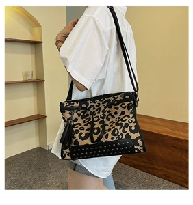 Close-up of leopard print crossbody bag with metallic rivets and side tassel detail