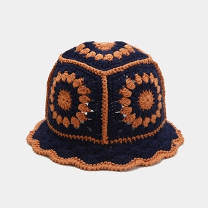 Detailopname van de marineblauwe gehaakte vissershoed met oranje bloemmotieven