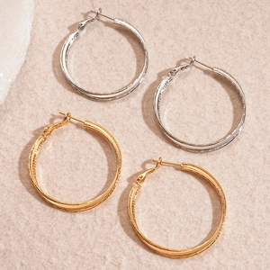 18k gold and silver plated double-layer cross hoop earrings on a stone textured background