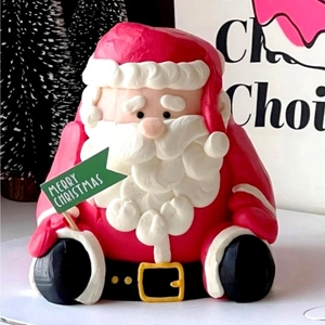 Close-up of Santa Claus cake topper holding a green Merry Christmas flag for holiday party