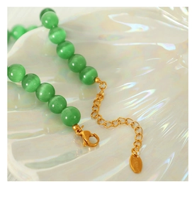 Close-up of green cat eye beads and S925 silver clasp on a colorful beaded necklace