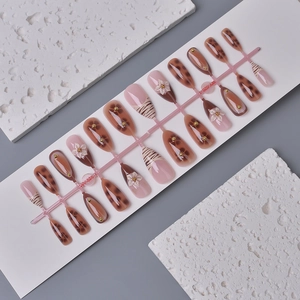 Detail of leopard print press-on nails with 3D floral accents and French tips