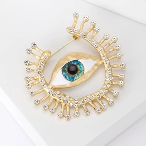 Broche œil élégante plaquée or avec iris turquoise et cristaux strass scintillants